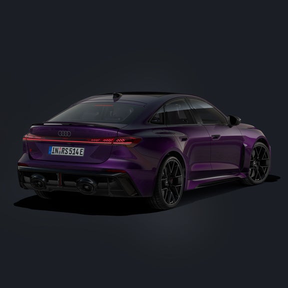 Die RS 5 Limousine schräg von hinten mit Indivuallackierung in Merlin Perleffekt und 21-Zoll-Rändern im 6-Doppelspeichen-Design in Schwarz, daneben eine Ladesäule.