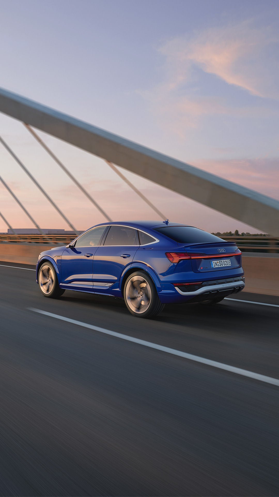 Blauer Audi SQ8 Sportback e-tron fährt über eine Brücke