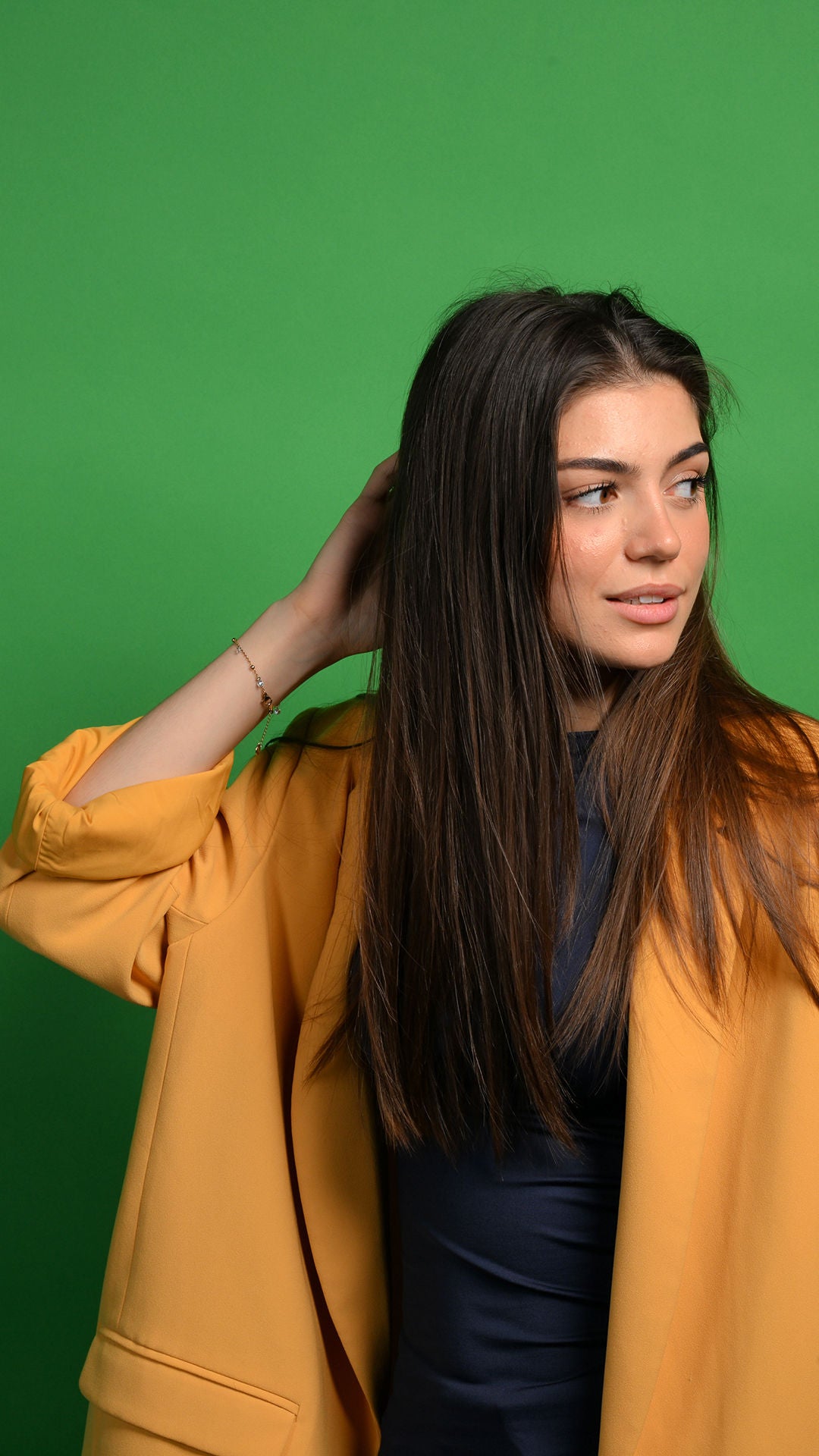 Emilia hat eine Hand am Kopf und schaut nach rechts