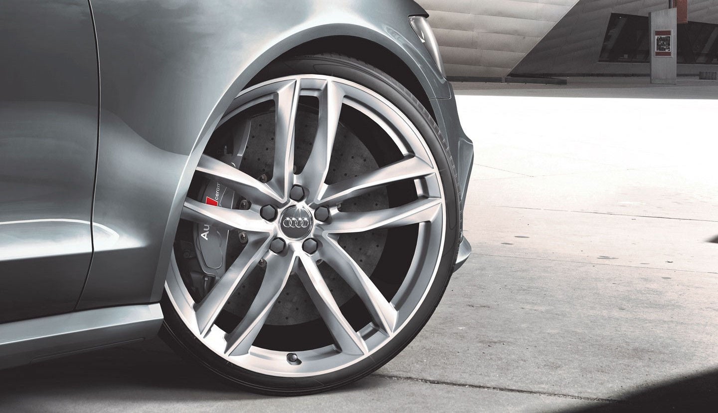 The front right of a silver Audi vehicle, the front right wheel is turned out to the right