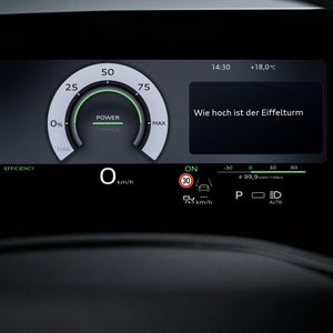 Nahaufnahme eines Displays im Fahrzeuginnenraum. Neben einer Energieanzeige ist in einem Feld lesbar "Wie hoch ist der Eiffelturm".