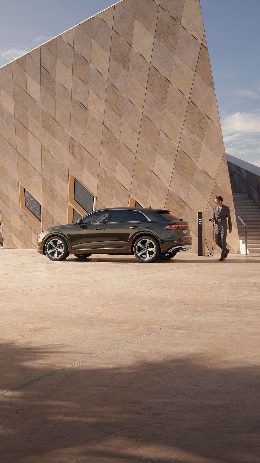 Q8 SUV TFSI e Seitenansicht mit Person die da Auto laden möchte