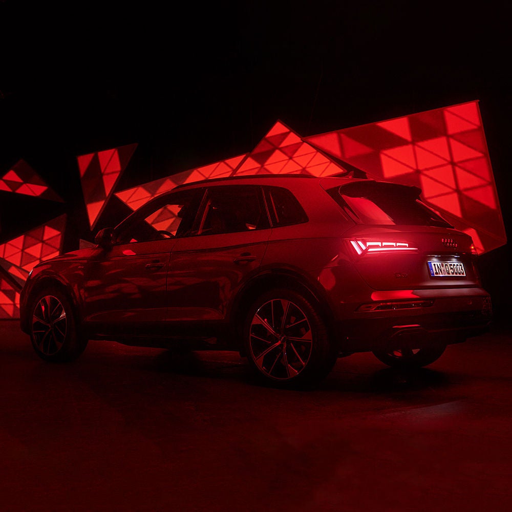 Audi e-tron drives along the low-lying sun.