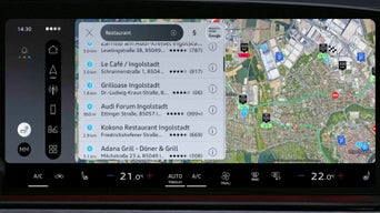 Visor do veículo com pesquisa de destinos do Google; são exibidos termos de exemplo, como “pizza” ou “parque infantil”.