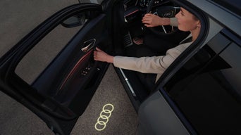 Frau steigt aus einem Audi mit Einstiegs-LED