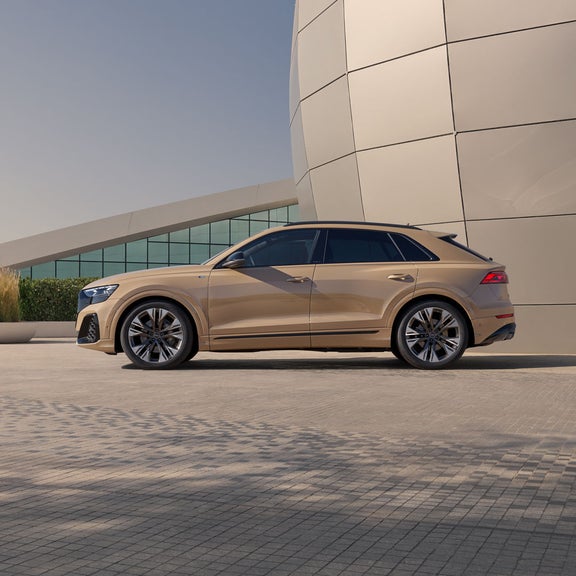 Der Q8 SUV von der Seite, parkend vor einem futuristischem Gebäude.