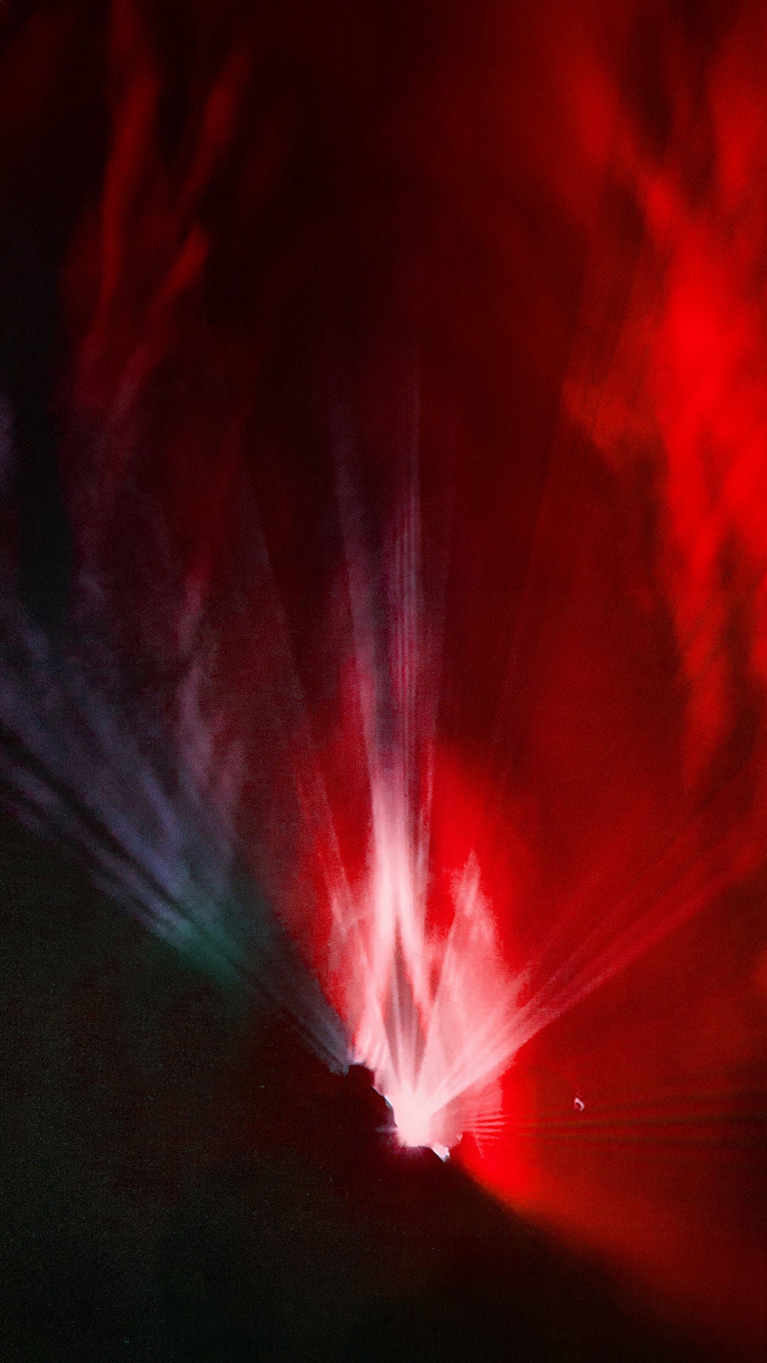 Farbiges Lichtspiel. Die Linke Bildhälfte ist durch rotes Licht erleuchtet nach rechts wechslet es in einen blaulila Farbverlauf. Während die untere linke Bildhälfte in Schwarz getaucht ist.