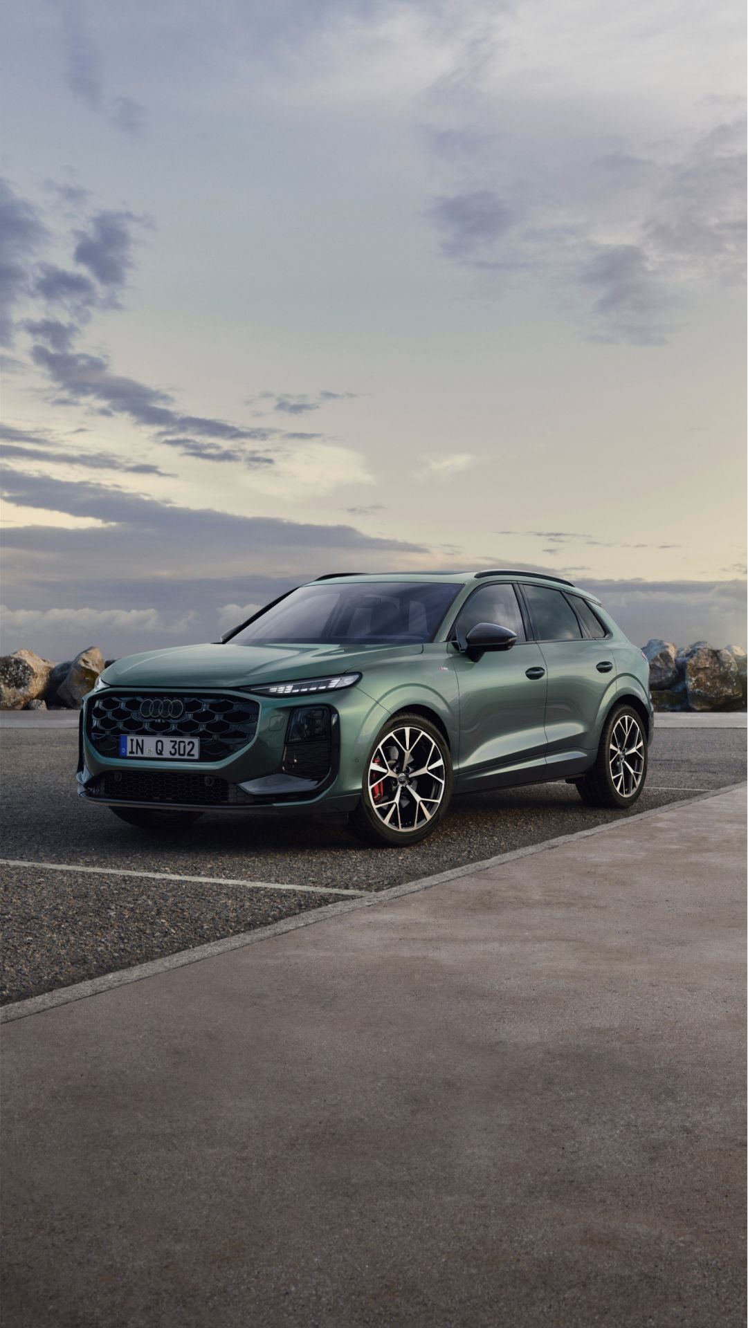 A green Audi Q3 SUV parked