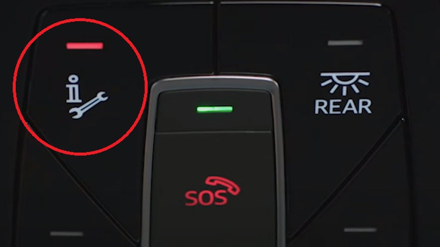 Detailansicht eines Fahrzeuginnenraums mit SOS-Taste, Service-Symbol mit rotem Licht und Taste für hintere Beleuchtung.