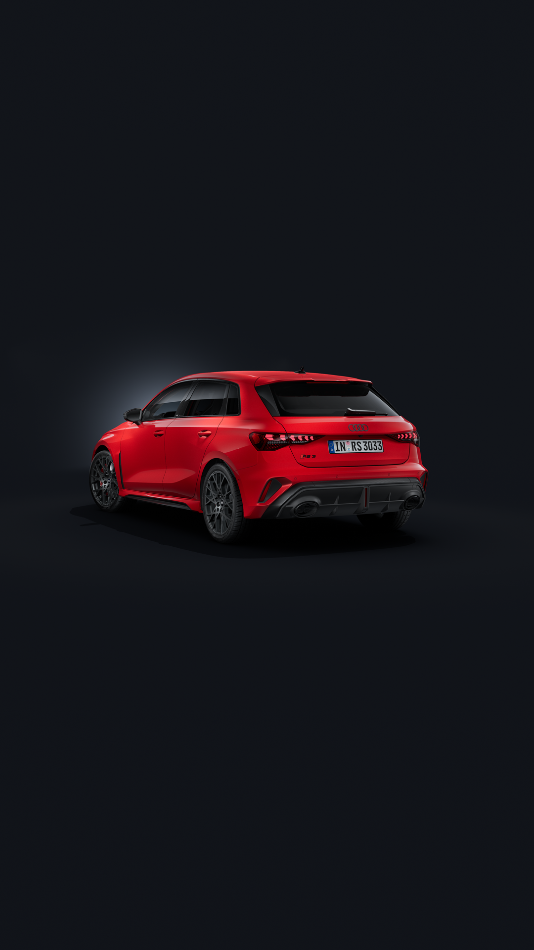 Audi RS 3 Sportback, sedd snett bakifrån mot en mörk bakgrund.