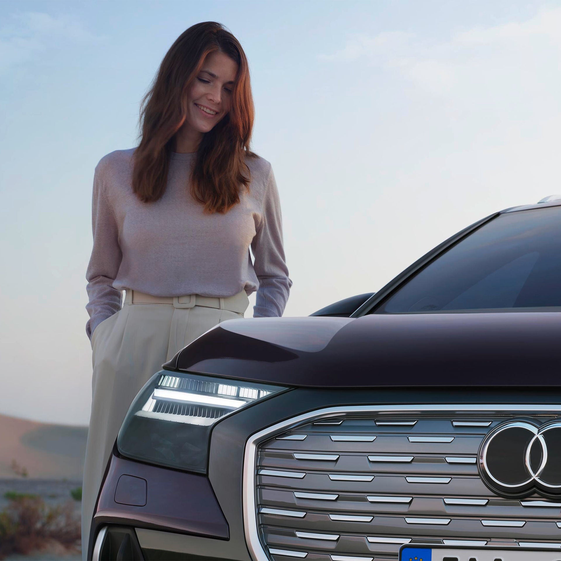 Kvinna bredvid svart Audi Q4 e-tron