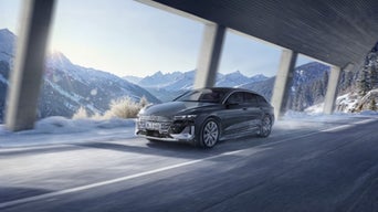 Audi S6 e-tron durchfährt vor verschneiter Bergkulisse eine Galerie