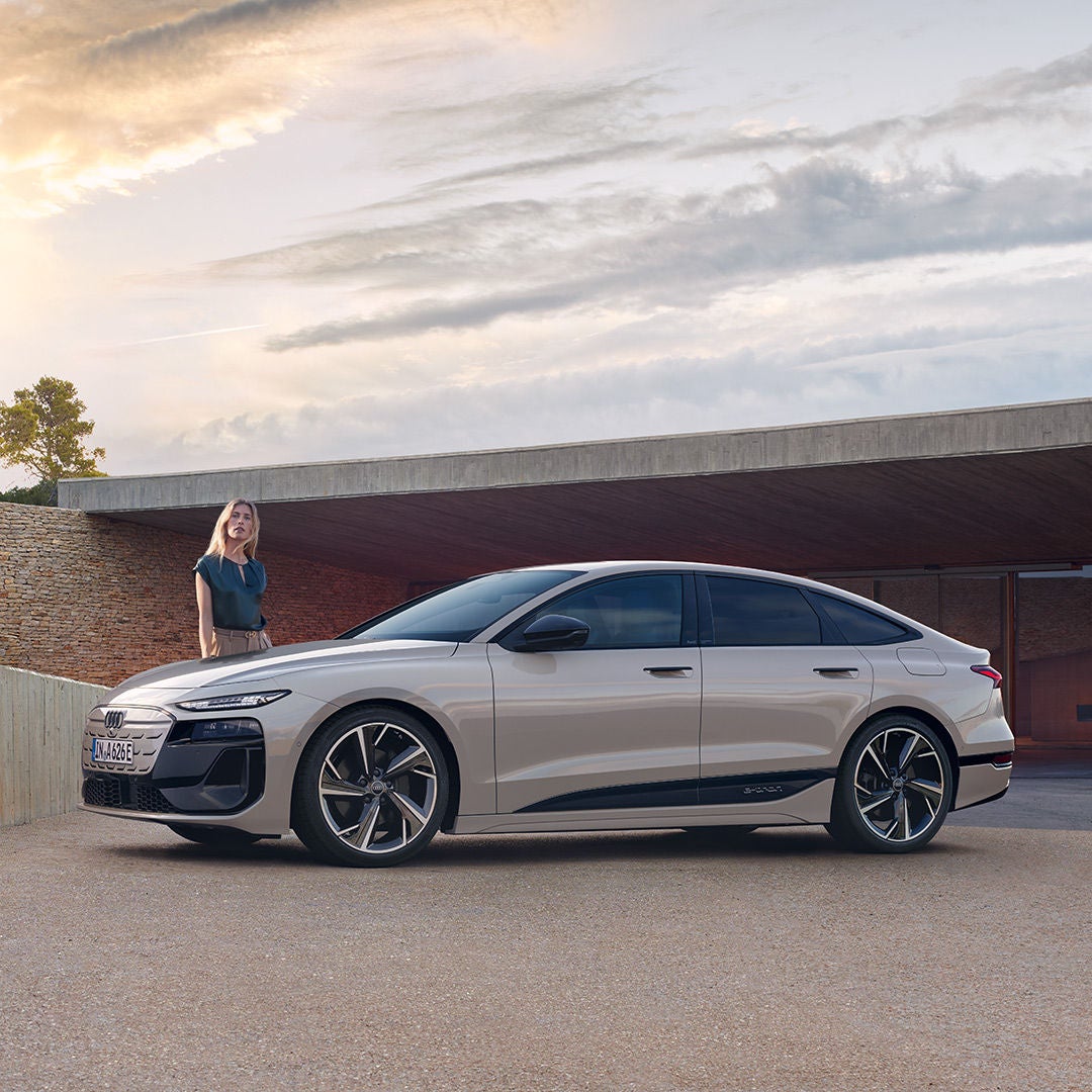 A6 Sportback e-tron sedd från sidan står parkerad med en person i bakgrunden