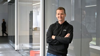 Alex, Office Lead SDC, schaut mit verschränkten Armen in die Kamera