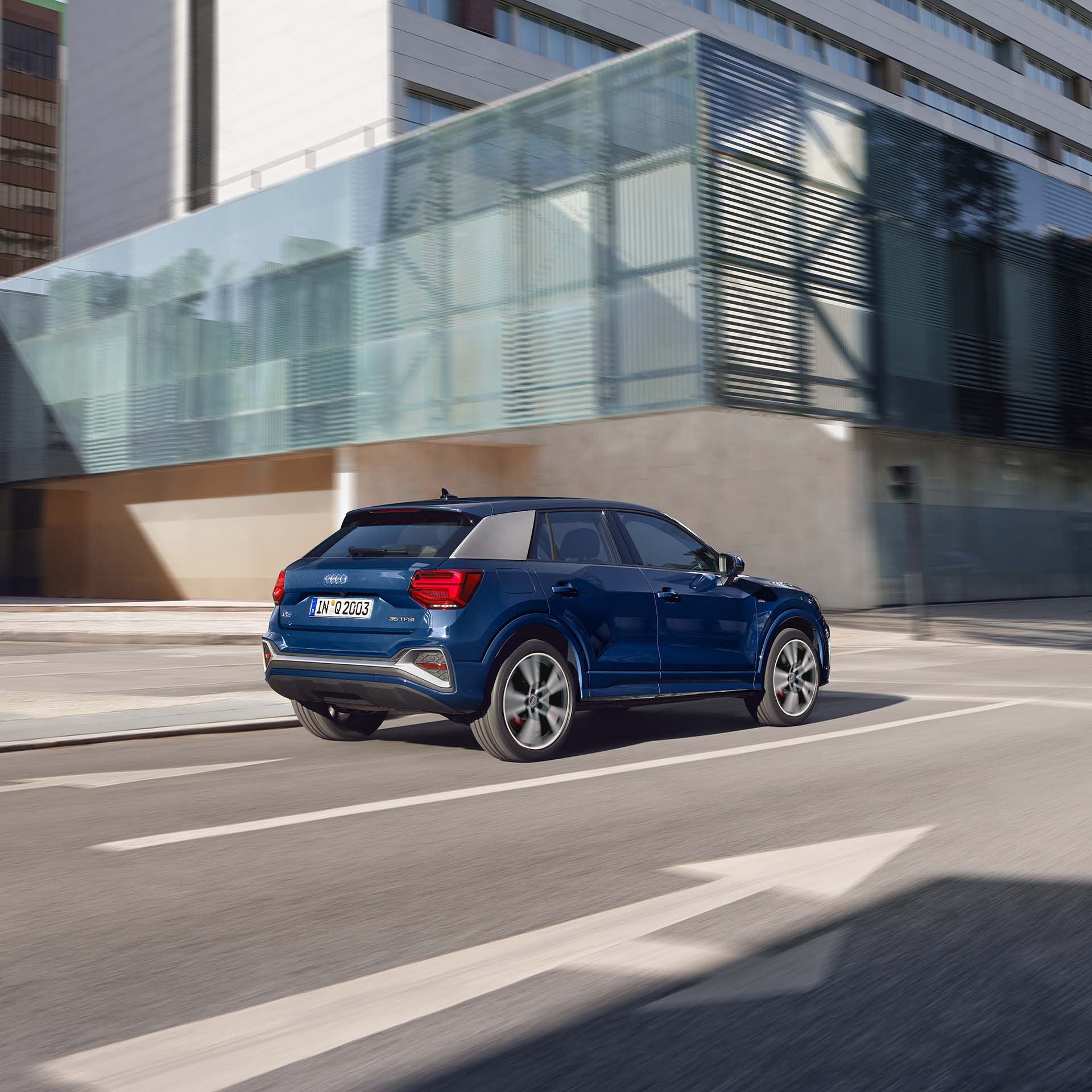 Vista trasera de una camioneta azul Audi Q2 a toda velocidad 