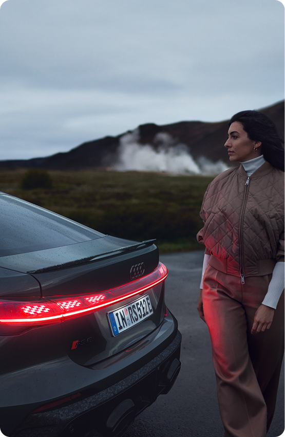 Driver walking behind Audi sedan