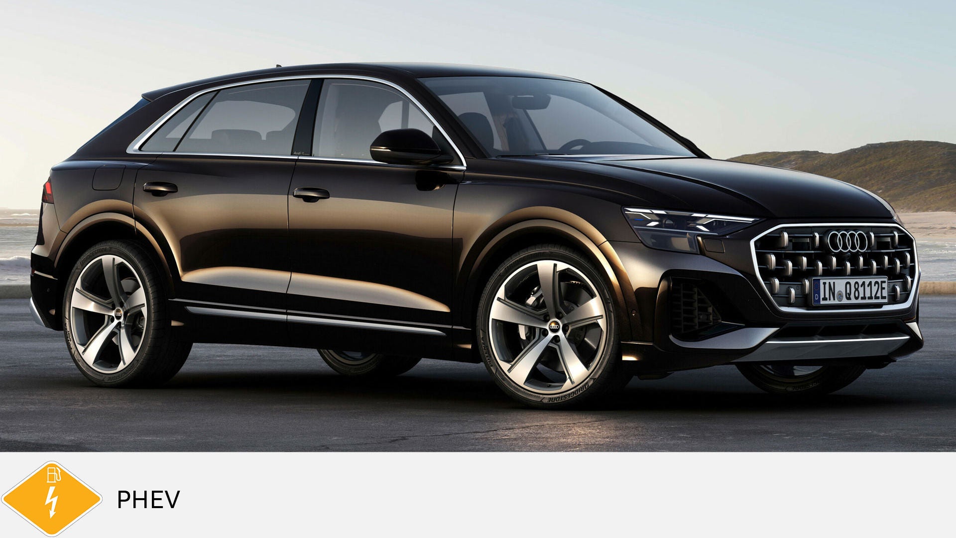 Black Audi Q8 TFSI e standing on asphalt on the coast in daylight. Below, yellow PHEV symbol with petrol pump and lightning bolt.