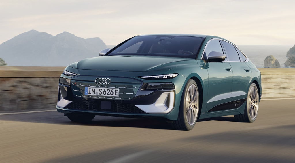 Der S6 Sportback e-tron im schrägen Frontprofil, während er eine Küstenstraße entlangfährt.