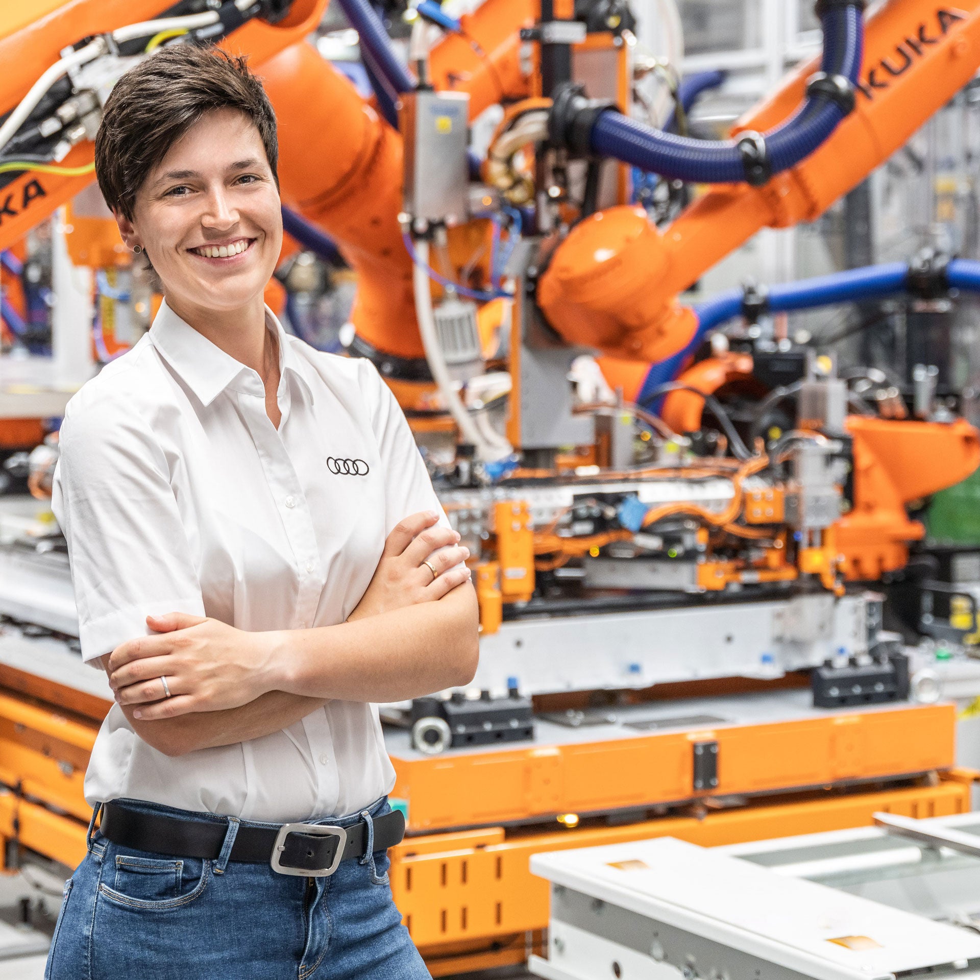Maria Salbeck vor Roboter in der Batteriemontage