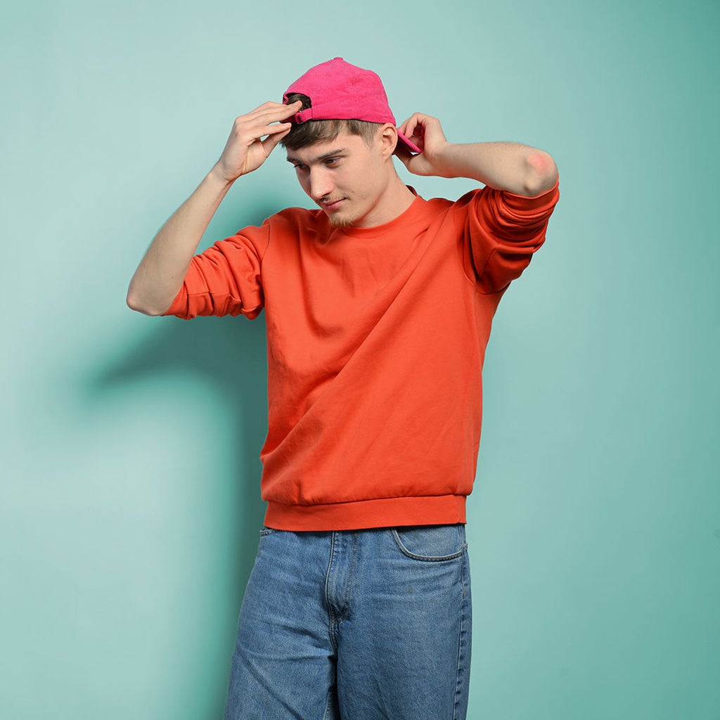 Noah schaut nach links und richtet seine Cap