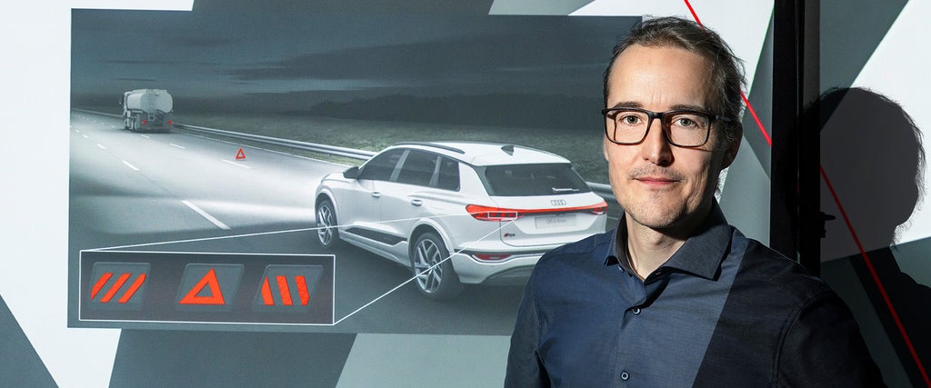 Porträt von Christoph Liebelt neben einer Darstellung zur Fahrzeugsicherheit