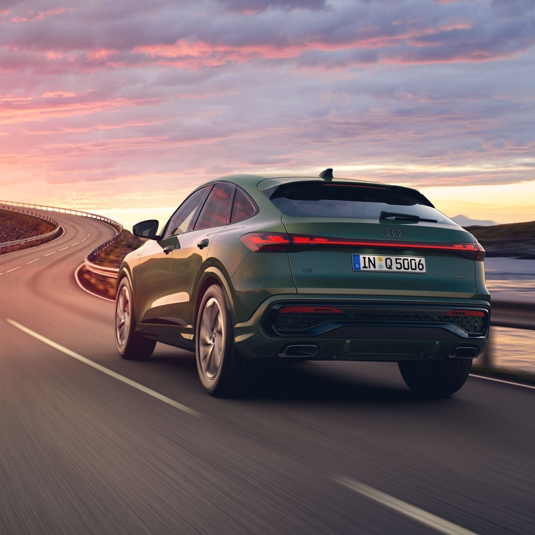 Dwa samochody Audi stojące obok siebie z pięknym niebem z tyłu