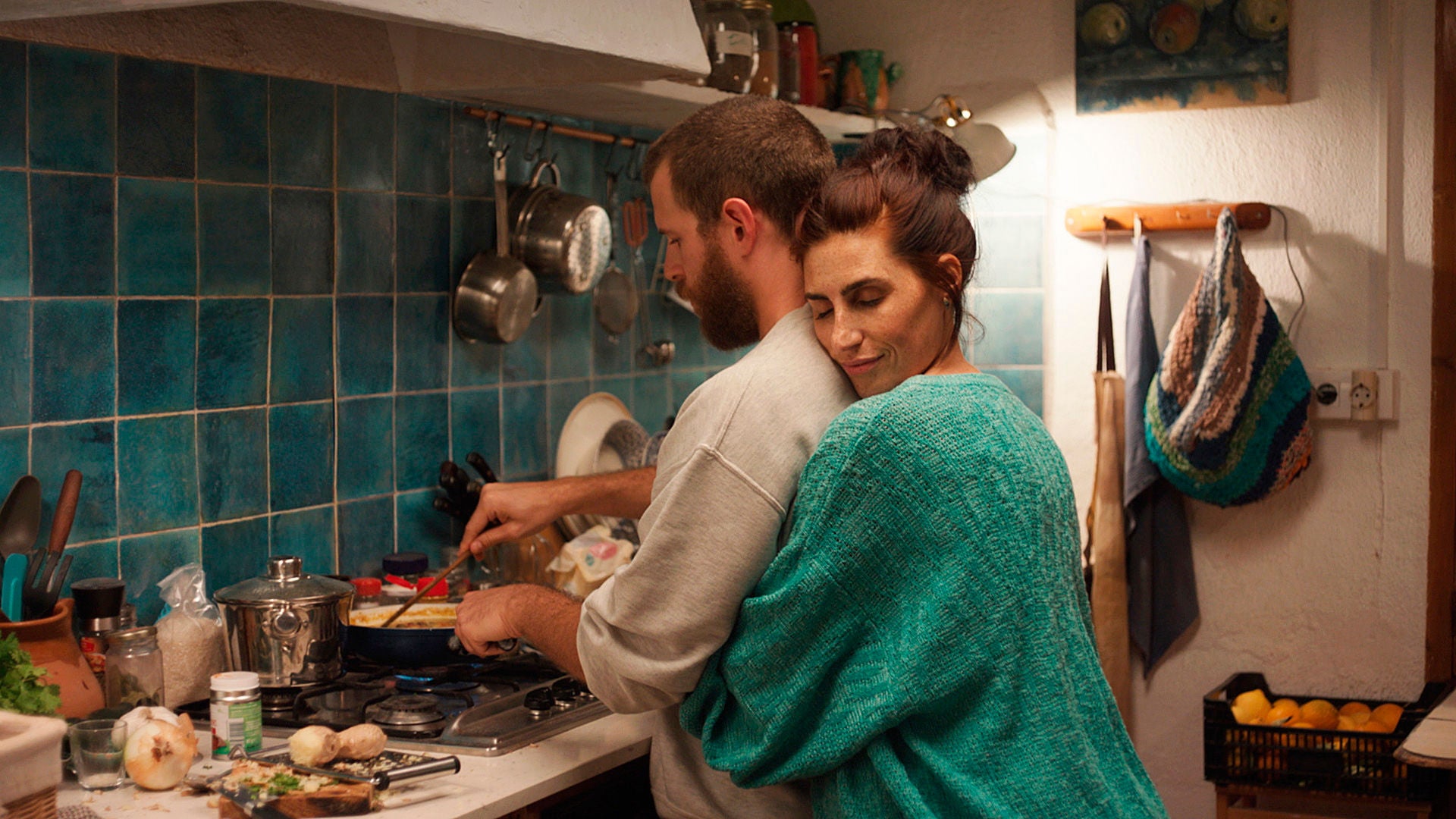 Die gehörlose Angela umarmt ihren Mann Hector, der gerade das Essen vorbereitet.