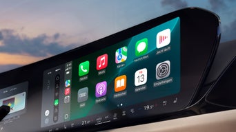 Nahaufnahme eines Touchscreens im Audi mit geöffneter Smartphone-Schnittstelle, Apps wie Telefon, Musik und Karten sichtbar.