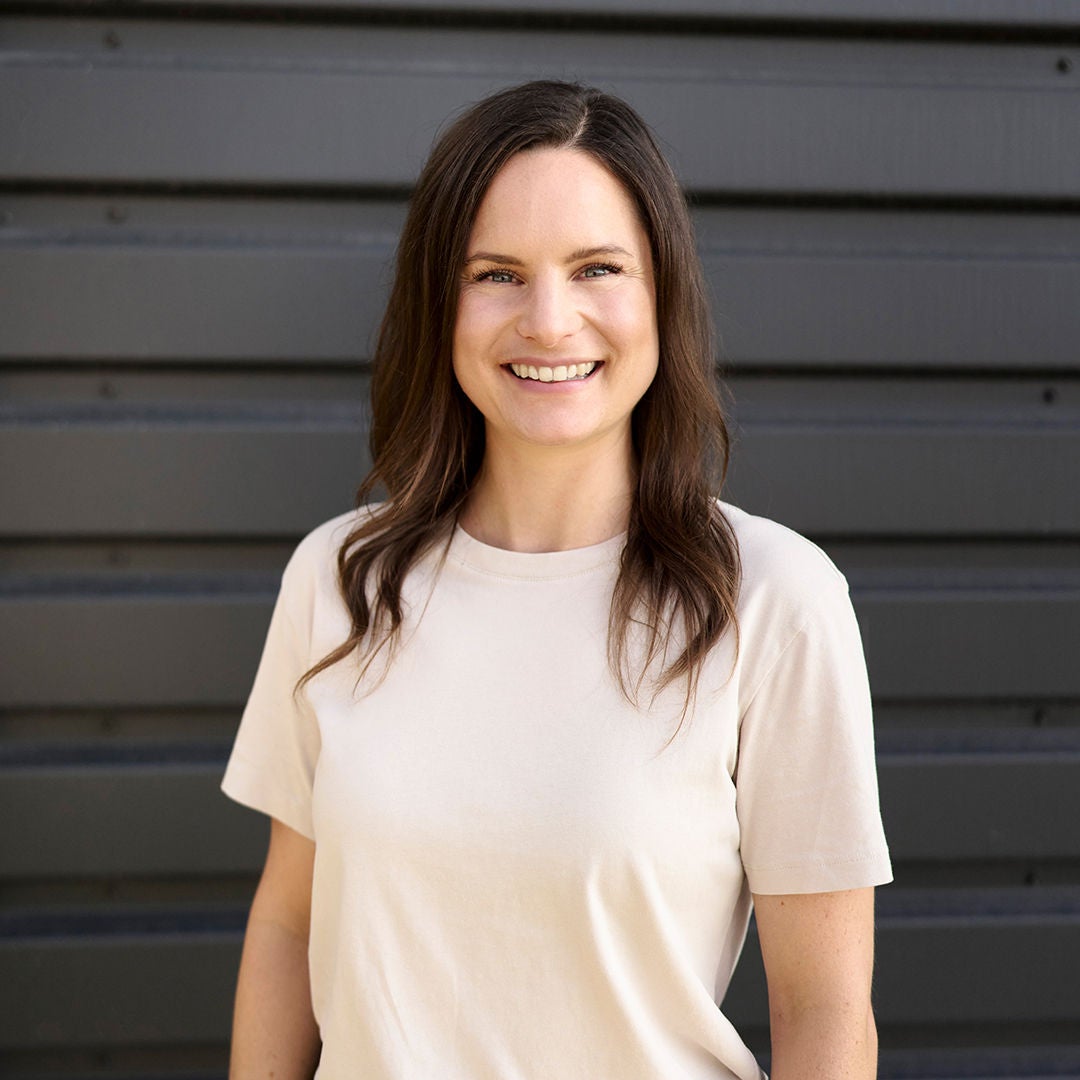 Melanie Schillinger looks into the camera and wears a white shirt