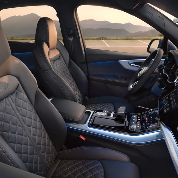 Car interior with leather seats, modern dashboard, and ambient lighting.