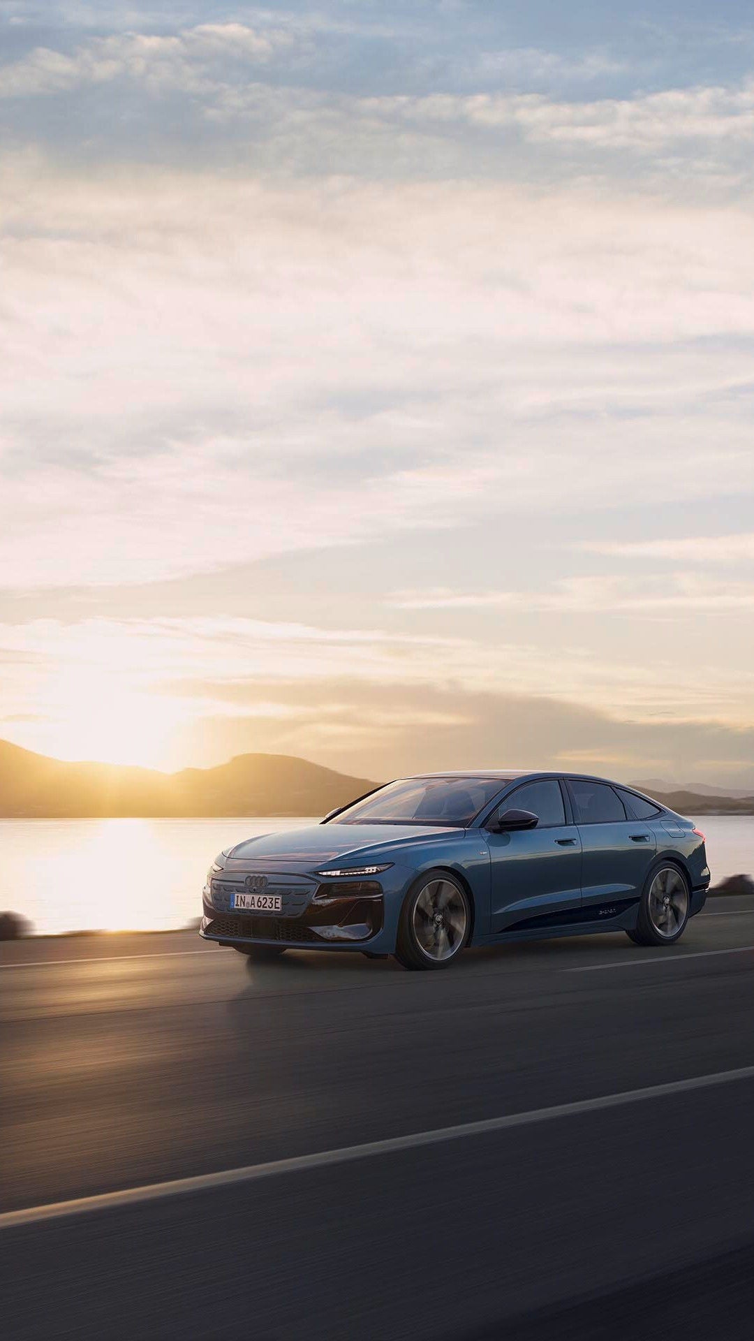 Driving Audi A6 Sportback e-tron performance in front of a setting sun.