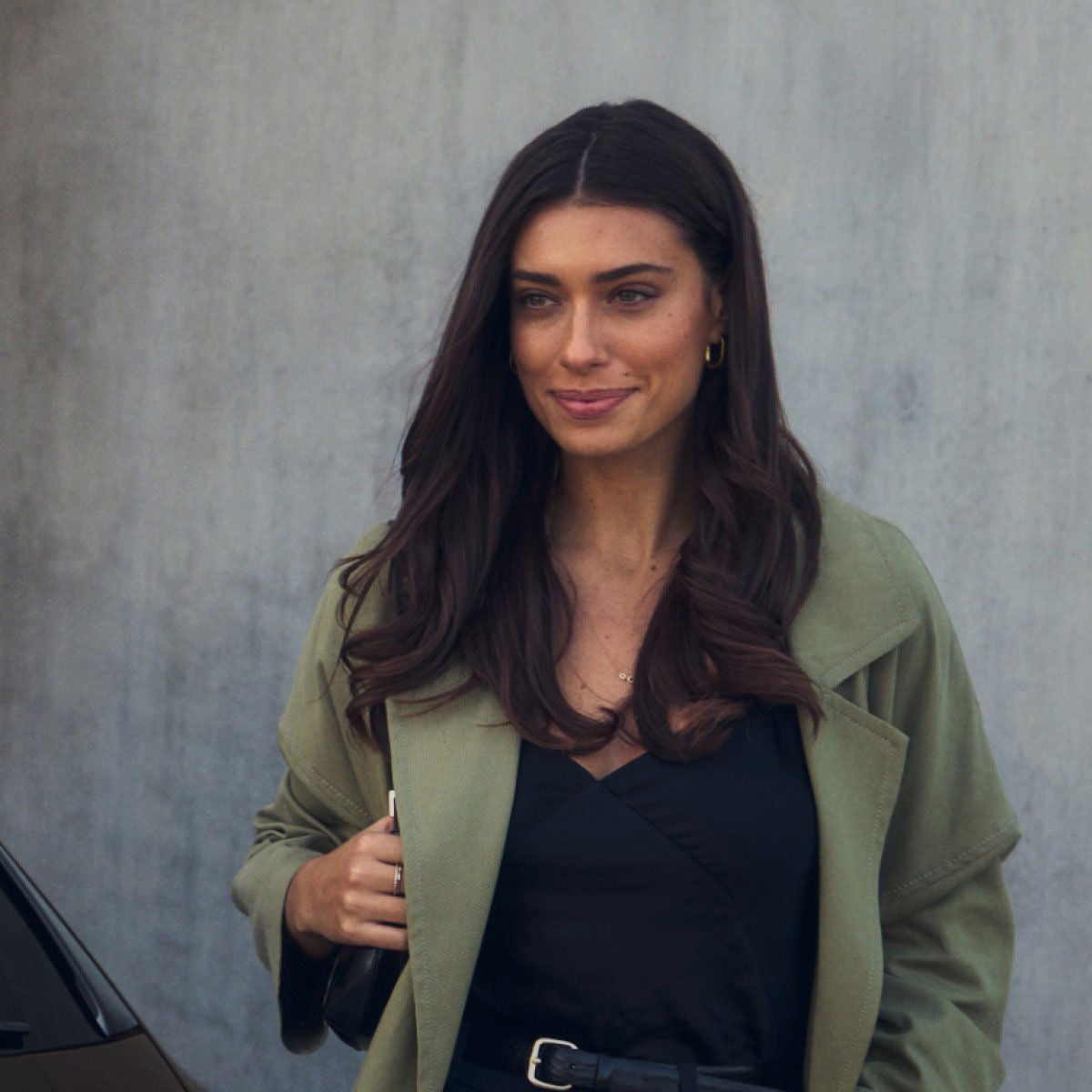 Close up of a woman walking near an Audi car's rear