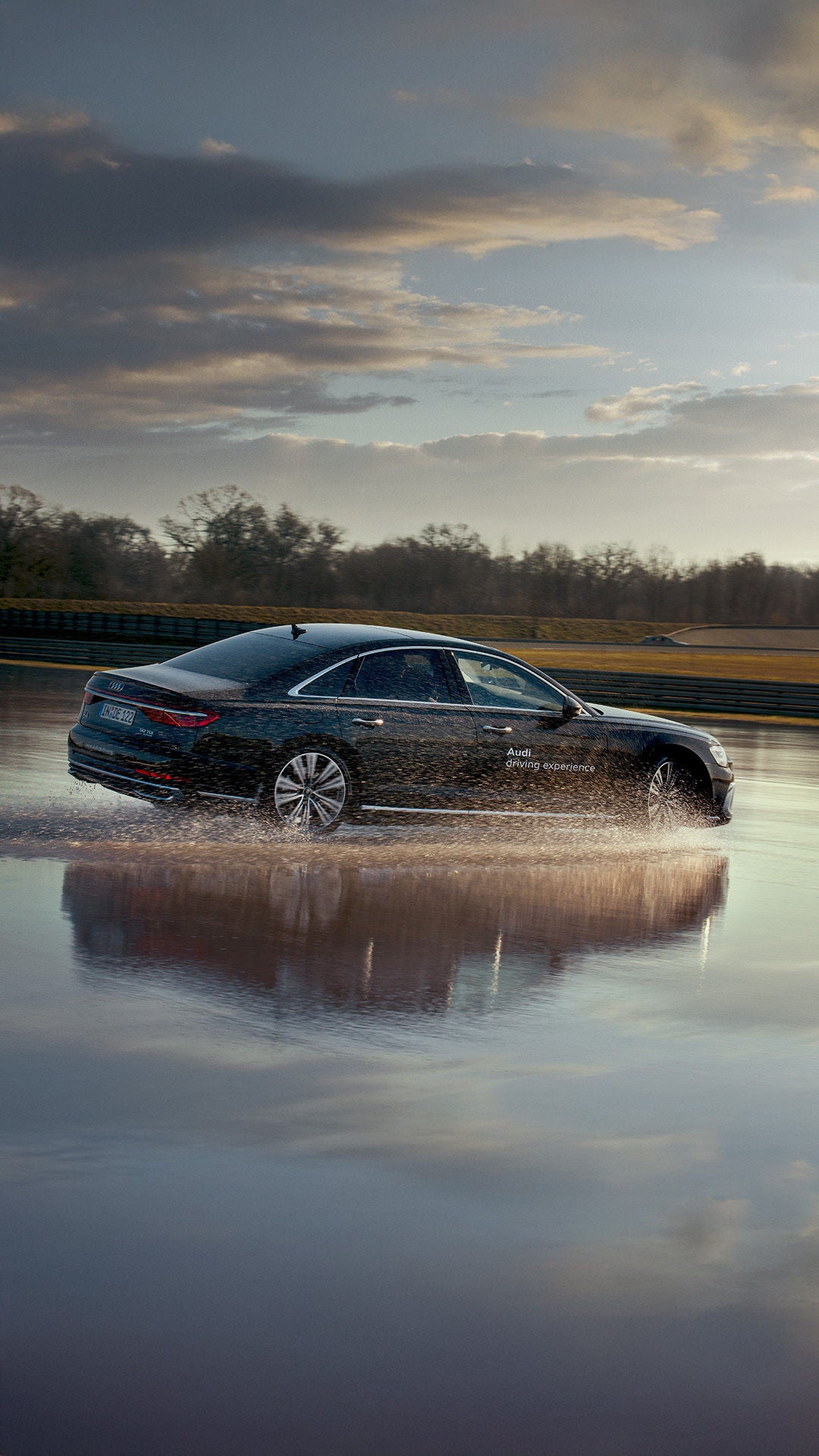 Schwarzer A8 50 TDI quattro driftet auf nasser Fahrbahn.