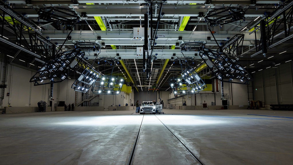 Weißer Audi in einer großen Testhalle unter spezieller Beleuchtung