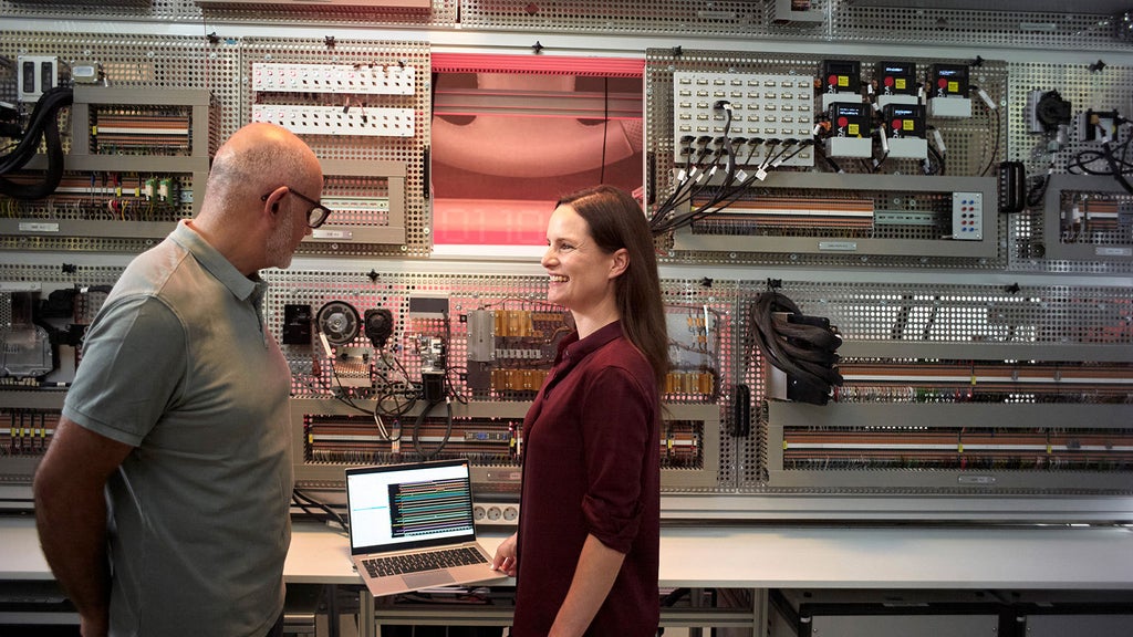 Melanie Schillinger discusses with a colleague in a room with technical equipment