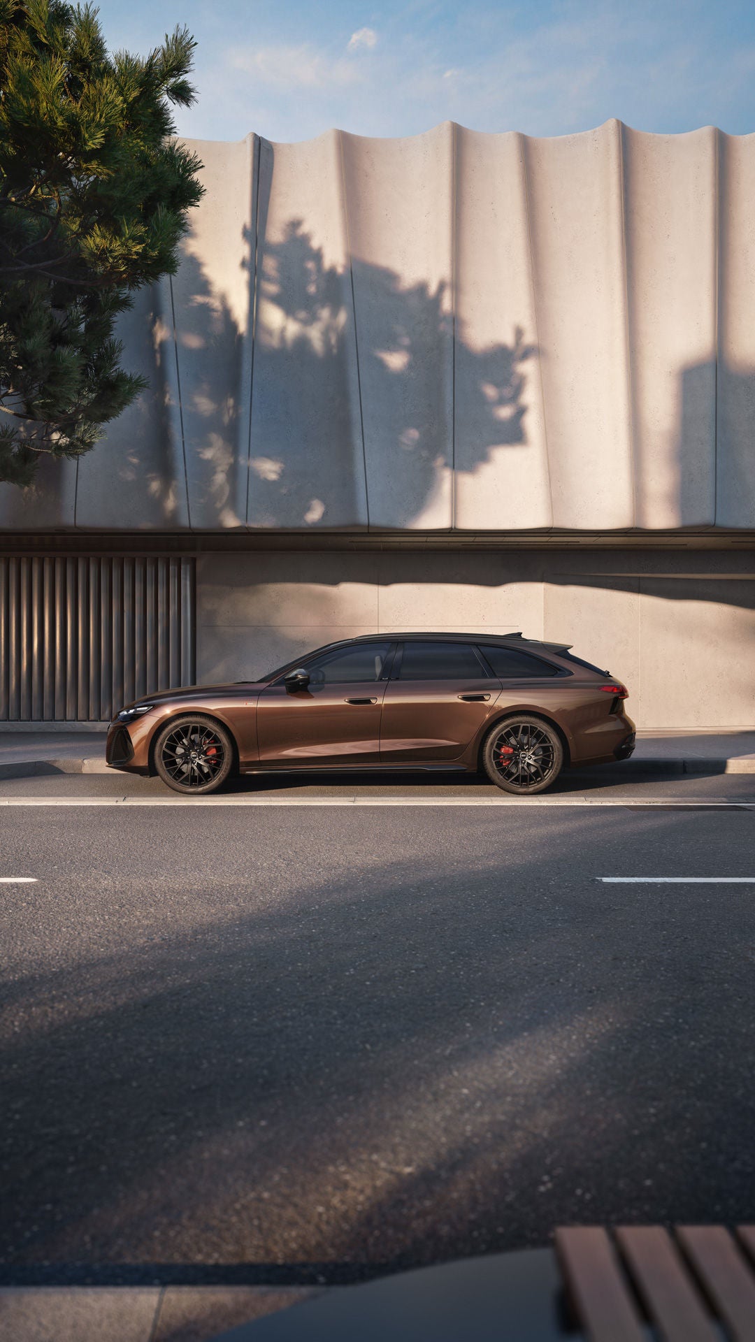 Der A6 Avant steht im Seitenprofil in einer Parkbucht vor der Fassade eines Gebäudes.