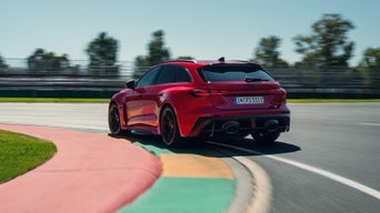 Ein Audi RS 5 Avant fährt in eine Kurve einer Rennstrecke.