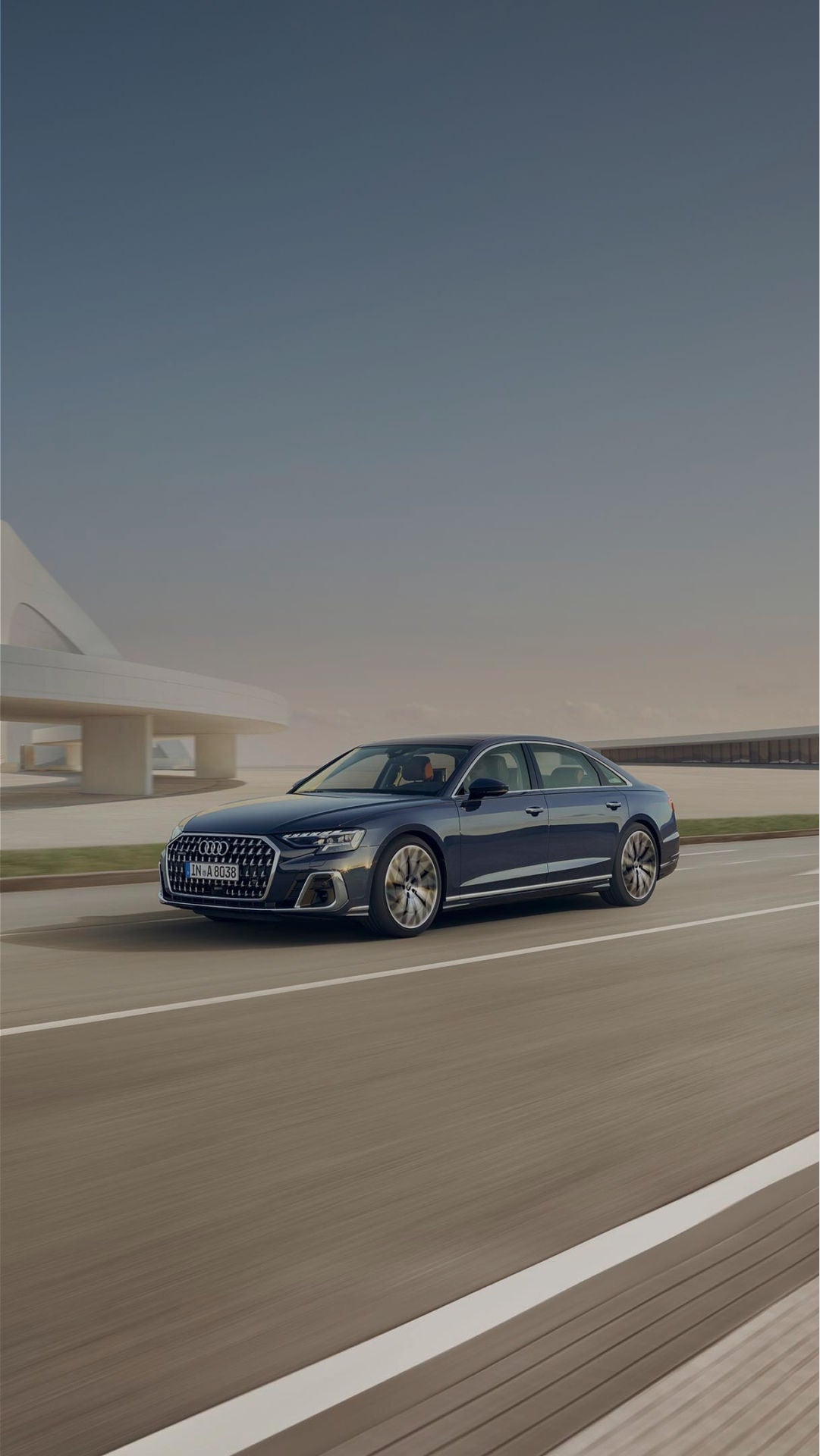 A blue saloon Audi car while in motion on the road