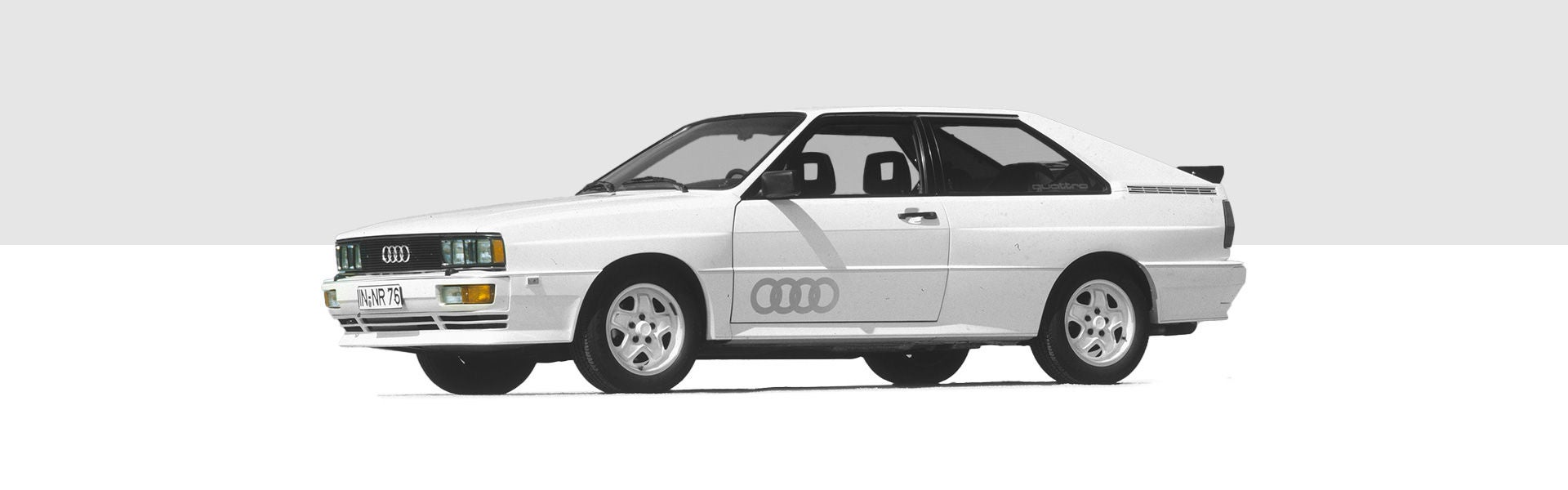 Illustration des Audi quattro in Weiß auf grau-weißem Hintergrund