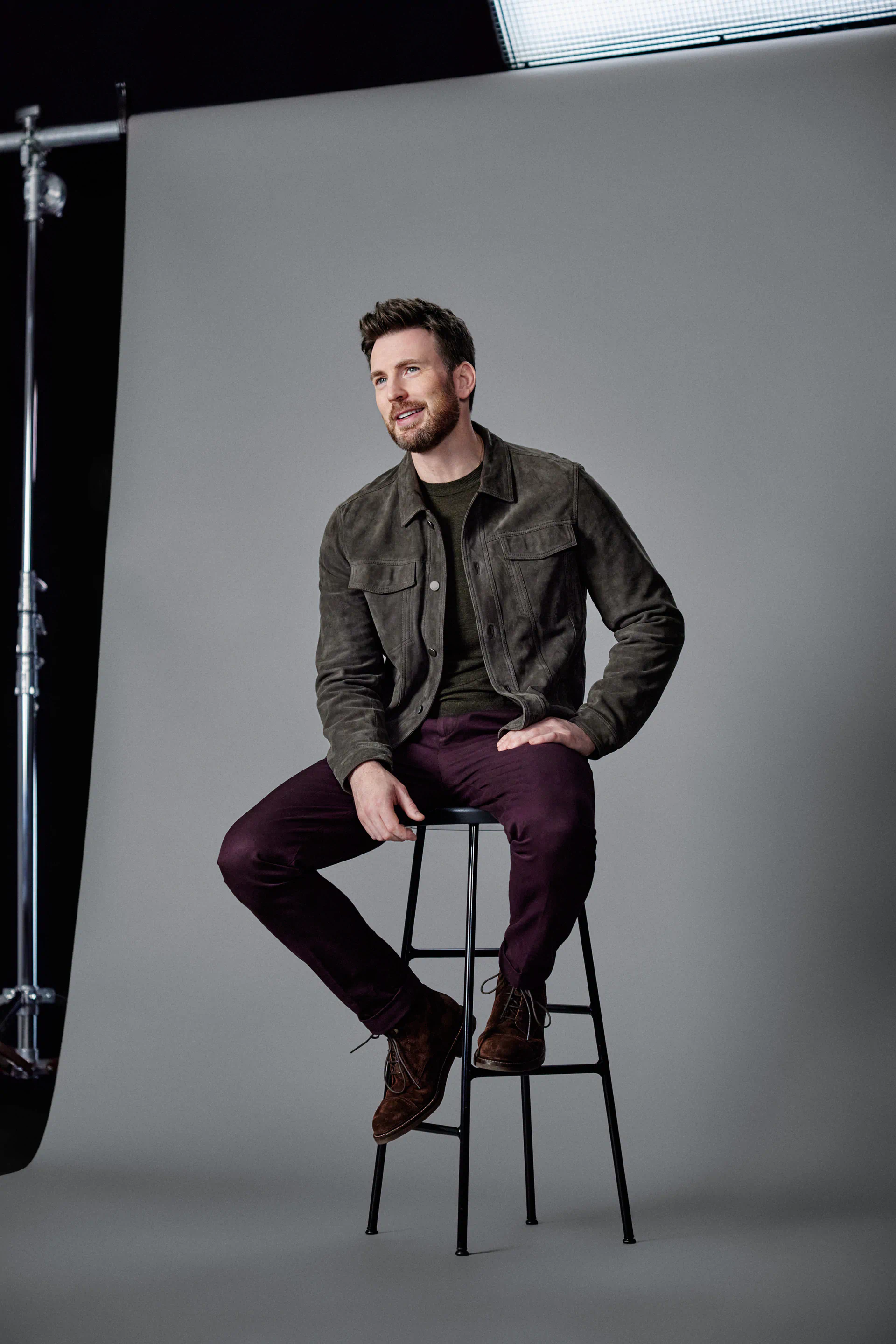 Chris Evans is sitting on a chair.