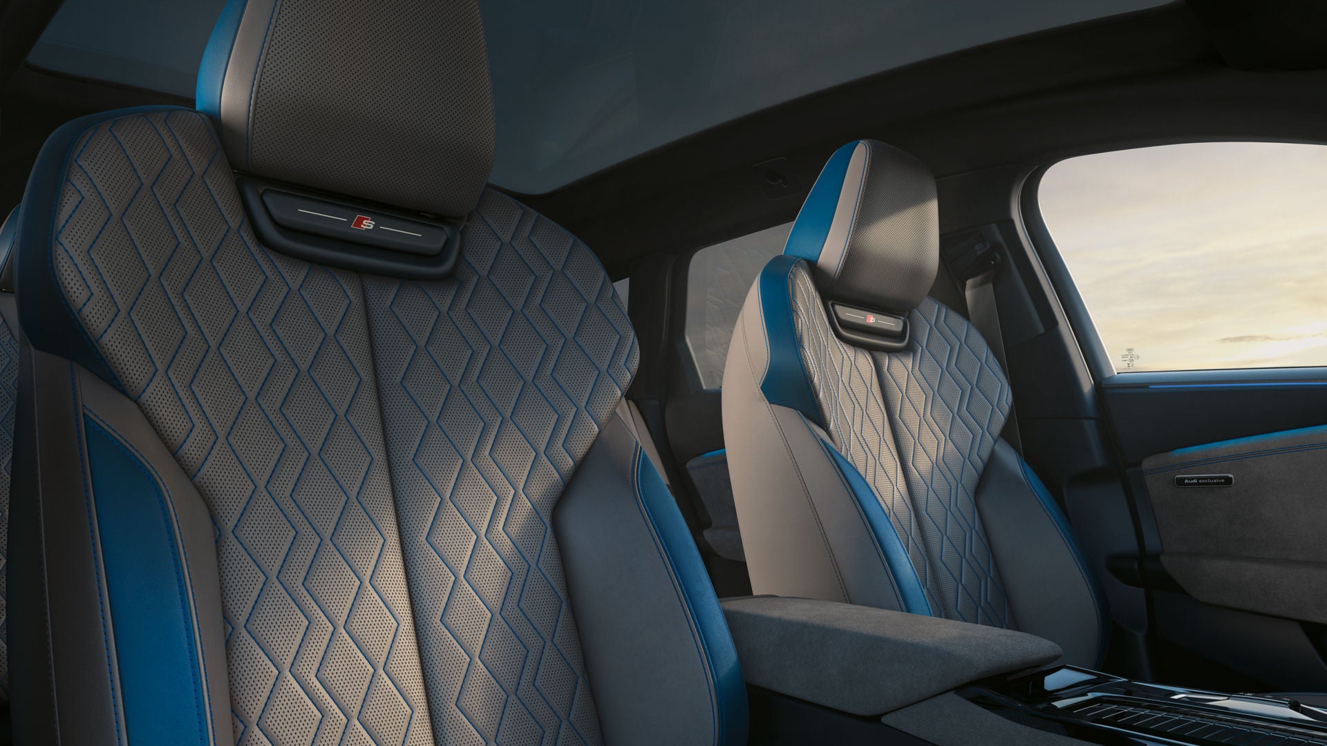 Die vorderen beiden Sitze des S6 Avant e-tron aus der Perspektive des Beifahrerfensters. Das Interieur erscheint in dem Designpaket Jetgrau/Ozeanblau.