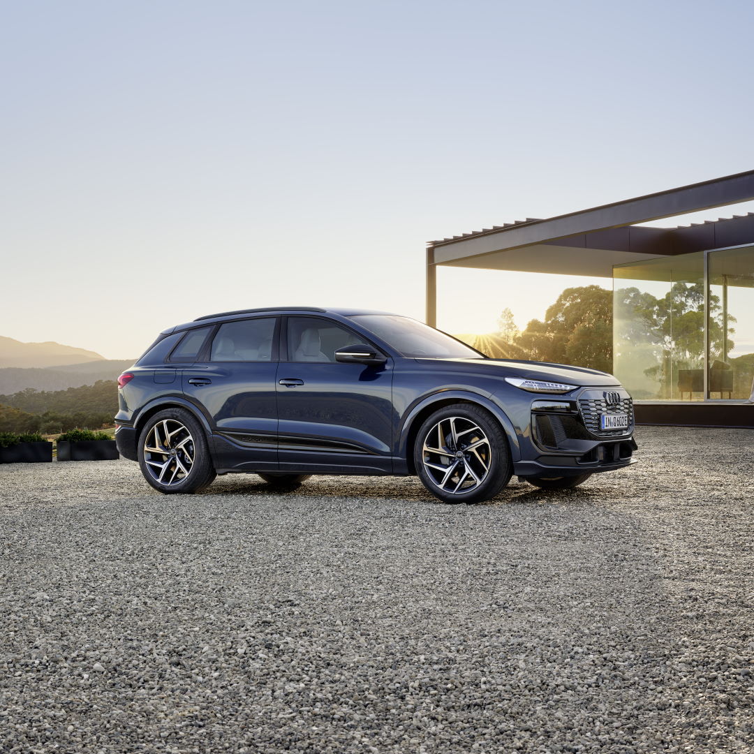 Blue Audi Q6 e-Tron model parked outside a modern building
