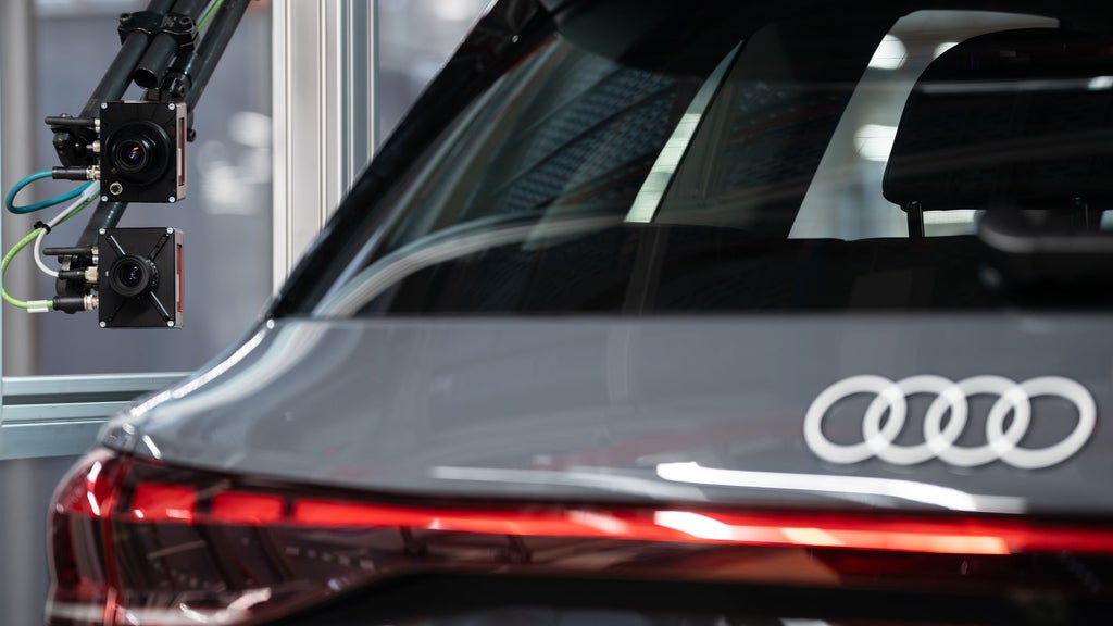 Grey Audi connected to external cameras and sensors in a production hall