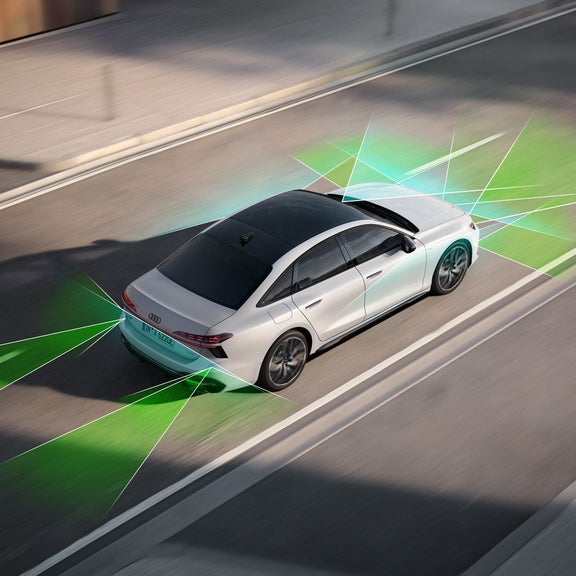 Die A6 Limousine e-hybrid von schräg oben. Vom Heck und der Front aus unterteilen grüne und blaue Vektoren die Flächen hinter und vor dem Fahrzeug.