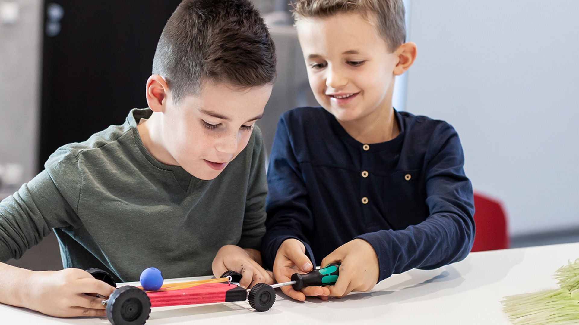 Zwei Kinder arbeiten gemeinsam an der Entwicklung eines Rennfahrzeugs