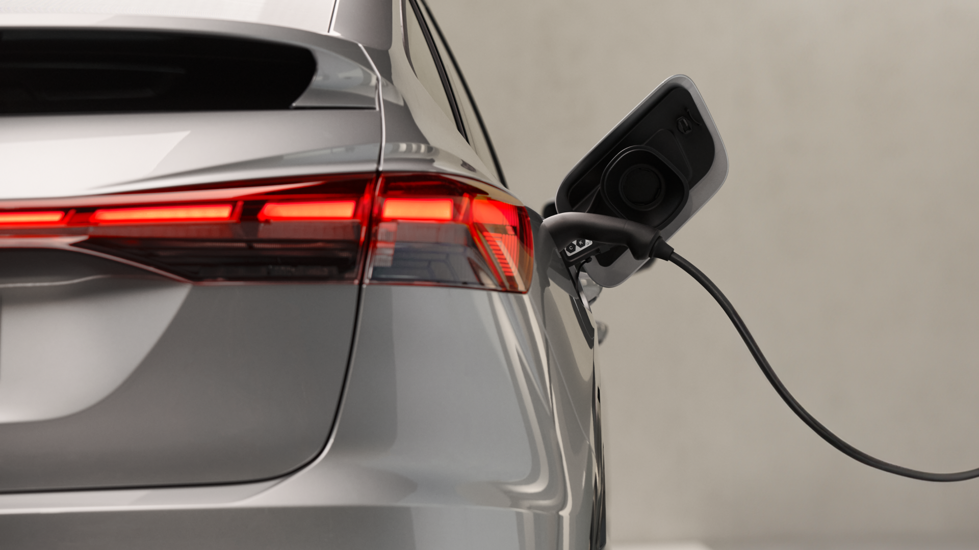 Close up of the rear right side of an Audi vehicle on charge with the back light illuminated