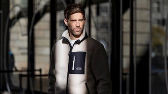 Mann in Audi Klamotten schaut an der Kamera vorbei
