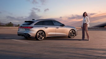 Audi A5 Avant står parkerad i solnedgången. En person står framför bilen.