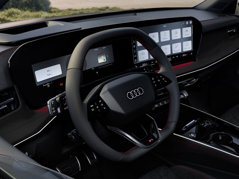 Front view of the steering wheel, center console, and digital displays.