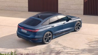 Blauer Audi A6 Sportback e-tron von schräg oben hinten, geparkt vor einer hellen Hausfassade.